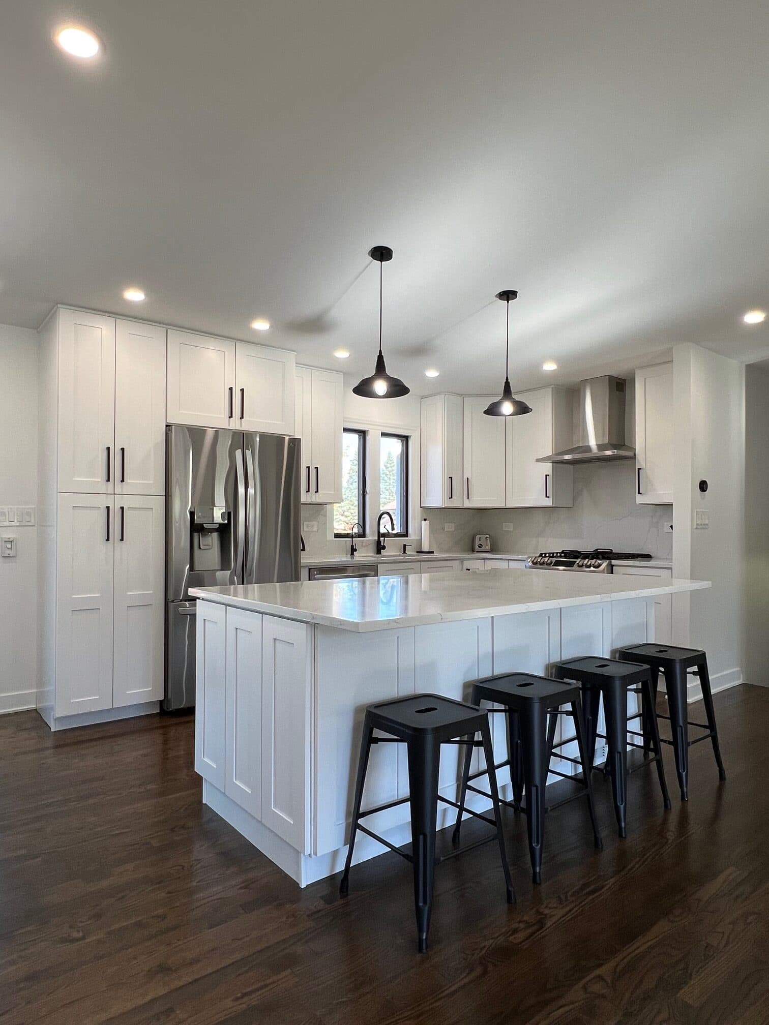 Bright, newly designed white kitchen with an island and pendant lighting