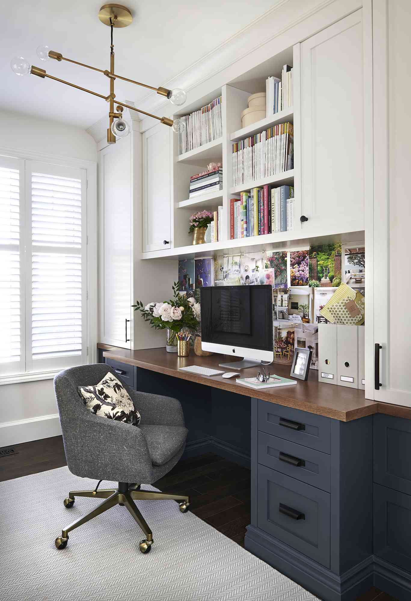 Organized home office with built-in navy cabinetry and tidy bookshelves