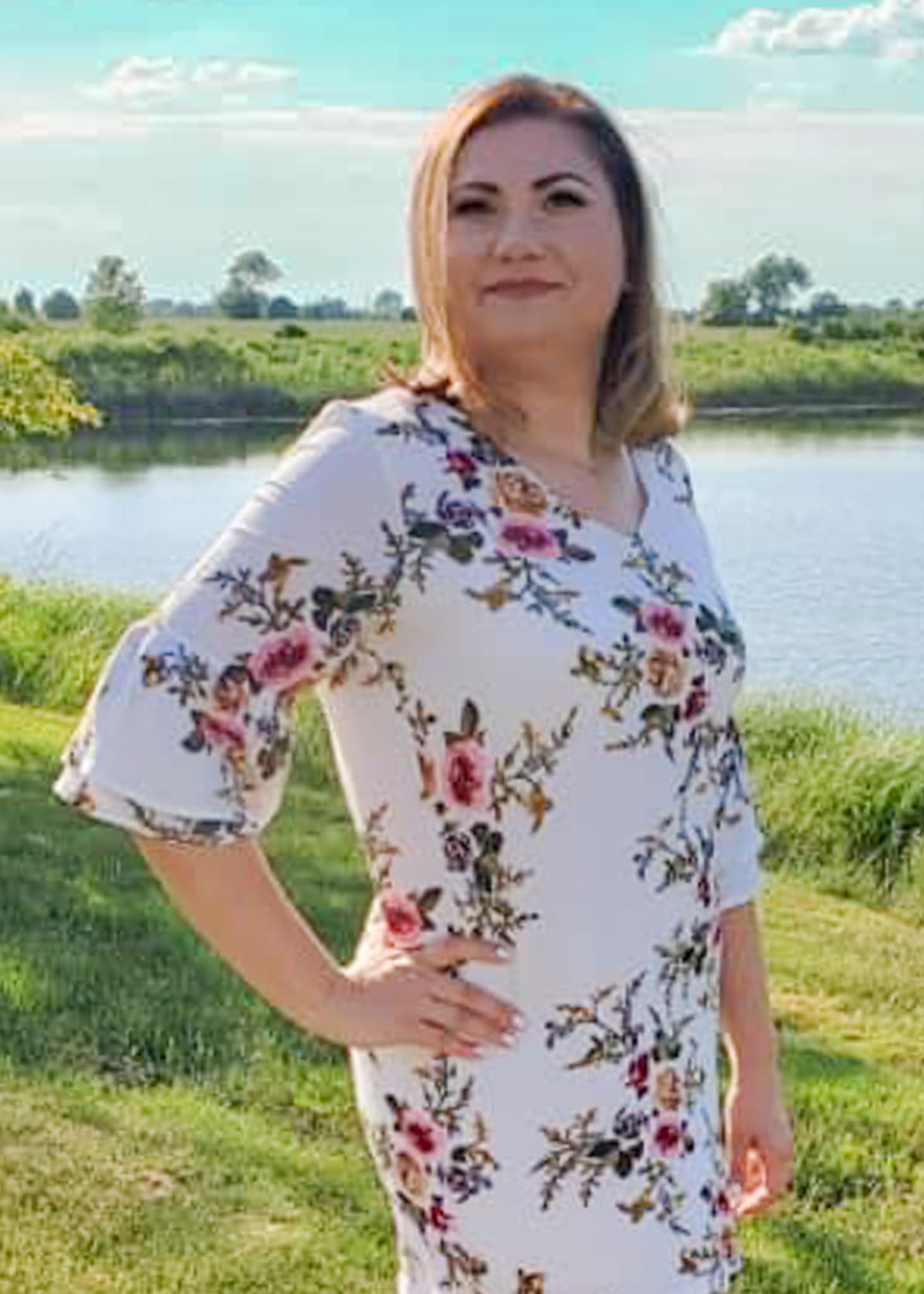 Portrait of Paulina Swietek-Gorski standing outdoors by the water in a floral dress