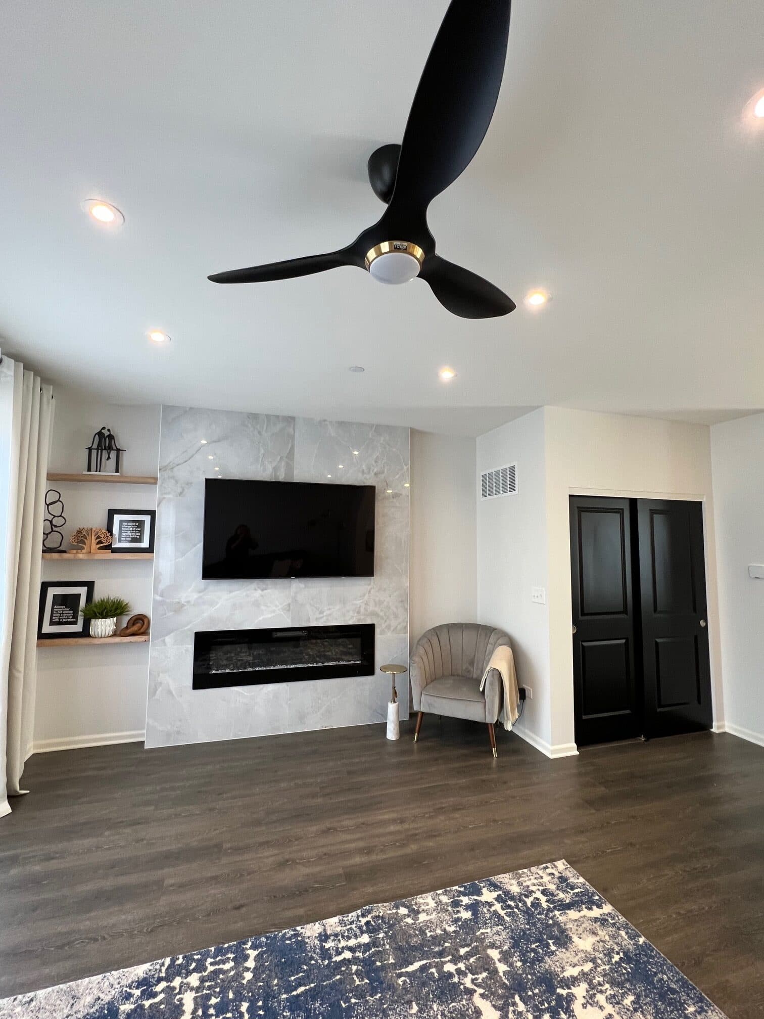 Staged living room with a marble fireplace feature wall and accent chair